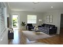 Cozy staged living room featuring a modern sofa and accent chairs at 6144 Elmhurst Dr, New Port Richey, FL 34653