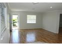 Bright room with hardwood floors, large windows, and neutral walls ready for personal touches at 6144 Elmhurst Dr, New Port Richey, FL 34653