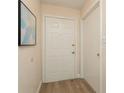 Inviting entryway with wood flooring, a six-panel door, and artwork on the wall at 6263 93Rd N Ter # 4202, Pinellas Park, FL 33782