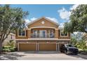 Two-story home featuring a balcony, a three-car garage, and a stone-accented facade at 7001 Interbay Blvd # 203, Tampa, FL 33616