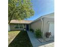 Inviting single-story home with well manicured landscaping leading to the front door at 7301 Mitchell Ranch Rd, New Port Richey, FL 34655