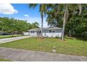 Single-story home surrounded by mature trees and lush greenery, offering a serene setting at 8897 54Th N St, Pinellas Park, FL 33782