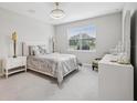 Serene bedroom featuring neutral colors, plush carpeting, and a large window with a view of the outdoors at 9107 Rally Spring Loop, Wesley Chapel, FL 33545
