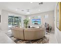 Bright living room featuring a large sectional sofa, a wall-mounted TV, and access to the outdoor pool area at 9107 Rally Spring Loop, Wesley Chapel, FL 33545