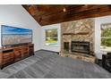 Inviting living room with a stone fireplace, vaulted wood ceilings, and ample natural light at 11203 Egret Nest Ct, Riverview, FL 33569