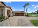 Spacious three-car garage with paneled doors and expansive decorative paver driveway at 11729 Newberry Grove Loop, Riverview, FL 33579