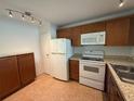 Well-lit kitchen includes tile flooring, white appliances, and granite countertops at 12300 Vonn Rd # 9105, Largo, FL 33774