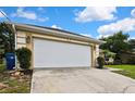 Spacious two car garage with a concrete driveway and landscaped yard at 12411 Talpa St, Spring Hill, FL 34608