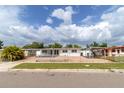 Quaint single-story home featuring a covered parking area and a fenced front yard at 1328 Waikiki Way, Tampa, FL 33619