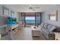 Light-filled living room with comfortable seating, a TV, and access to a balcony with stunning ocean views at 1340 Gulf Blvd # 16F, Clearwater, FL 33767