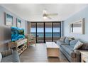 Bright living room with coastal decor, cozy seating, and sliding glass doors to a balcony overlooking the ocean at 1340 Gulf Blvd # 16F, Clearwater, FL 33767