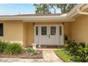 Close-up of the home's double door front entrance with decorative glass, a tiled porch, and fresh landscaping at 1370 Hill Dr, Largo, FL 33770