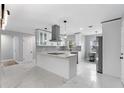 Modern kitchen featuring sleek white cabinetry, stainless steel appliances, and a spacious island at 1586 Linwood Dr, Clearwater, FL 33755