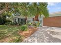 Charming home with a well-manicured lawn, mature landscaping, and an attached two-car garage at 1711 N Highland Ave, Clearwater, FL 33755