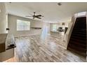 Open concept living area featuring wood-look tile floors, a fan, and an open staircase at 2612 E 26Th Ave, Tampa, FL 33605