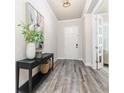 Inviting foyer with a decorative table, vase, and stylish gray wood-look floors at 2812 Long Bow Way, Odessa, FL 33556