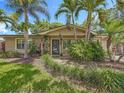 Inviting home exterior featuring tropical landscaping, a front door, and a manicured lawn at 3354 52Nd N St, St Petersburg, FL 33703