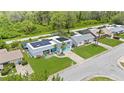 Beautifully landscaped property with solar panels, complemented by a lush green lawn and charming turquoise accents at 3519 Richboro Dr, Holiday, FL 34691
