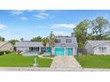 Well maintained single-Gathering home, showcasing a lush lawn and charming turquoise accents, perfect for a Gathering at 3519 Richboro Dr, Holiday, FL 34691