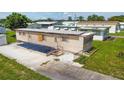 Home's beige siding is accented by green lawn and concrete driveway leading up to the front entrance at 37302 Carol Ave, Zephyrhills, FL 33542