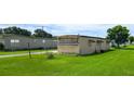 Rear exterior view of home situated on a green lawn showing the home's siding and outdoor space at 37302 Carol Ave, Zephyrhills, FL 33542