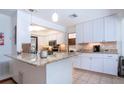 Bright kitchen featuring white cabinets, granite countertops, stainless steel appliances, and tile floors at 4205 Helene Pl, Valrico, FL 33594