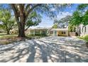 Inviting home featuring a spacious driveway leading to a well-maintained exterior with mature trees at 4417 W El Prado Blvd, Tampa, FL 33629