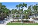 Charming single-story home features a well-manicured front yard with mature landscaping and a gravel driveway at 451 Avenida De Mayo, Sarasota, FL 34242