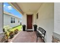Charming entryway featuring a brick paver floor, bench, and decorative potted plants at 5611 Del Coronado Dr, Apollo Beach, FL 33572