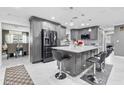Spacious gray kitchen features a center island with bar stools, modern appliances, and tile flooring at 5895 16Th N St, St Petersburg, FL 33703