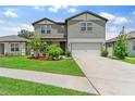 Charming two-story home featuring a lush lawn and an attached two-car garage at 6248 Bradford Woods Dr, Zephyrhills, FL 33542