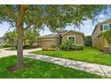 Charming single-Gathering home with a lush lawn and colorful flowerbeds lining the driveway and sidewalk at 6467 Seasound Dr, Apollo Beach, FL 33572