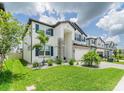 Attractive two-story home with stone accents, blue shutters, and a well-manicured lawn at 7700 Bronze Oak Dr, Wesley Chapel, FL 33545