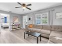 Neutral living room featuring a gray sectional sofa, bright windows, and stylish decor at 8108 E 19Th Ave, Tampa, FL 33619