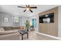 Bright living room with wood accent wall, recessed lighting, and neutral gray walls at 8108 E 19Th Ave, Tampa, FL 33619