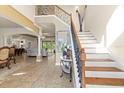 Grand foyer with staircase, tile flooring, columns, and open view to living spaces at 8358 Dunham Station Dr, Tampa, FL 33647