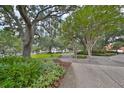 Serene exterior view showcasing a well-maintained pathway amidst lush landscaping and mature trees in a quiet community at 1 Beach Se Dr # 811, St Petersburg, FL 33701