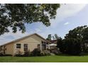 The backyard has a patio with a table, surrounded by lush landscaping, plants, and a manicured lawn at 11323 Highlander Ct, Spring Hill, FL 34609