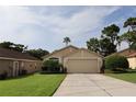 Attractive home with lush landscaping, a well-maintained lawn, and an attached two-car garage at 11323 Highlander Ct, Spring Hill, FL 34609