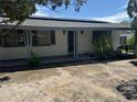 Charming single-story home featuring an inviting front porch and mature landscaping, and solar panels at 11423 77Th Ave, Seminole, FL 33772