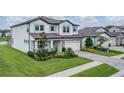 Beautiful two-story home with a paver driveway, manicured lawn, stone accents, and charming light blue shutters at 12189 Nouveau Ave, Spring Hill, FL 34610