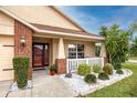 Inviting front porch with brick accents, lovely landscaping, and a cozy seating area at 12337 Rose Haven Blvd, New Port Richey, FL 34654