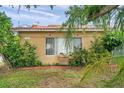 Charming house with terra cotta roof, red trim and mature plants in a desirable location at 1269 Drew St, Clearwater, FL 33755