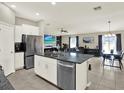 Open-concept kitchen with stainless appliances flowing into the living and dining areas at 12838 Wildflower Meadow Dr, Riverview, FL 33579