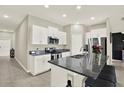 Bright kitchen with stainless steel appliances, granite countertops, and tiled floors at 12838 Wildflower Meadow Dr, Riverview, FL 33579
