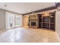 Spacious living room featuring a cozy fireplace, tiled floor, and large window at 13702 Sweetwater Cove Pl # 25, Tampa, FL 33613