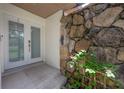 Covered entryway featuring double doors and a stone accent wall at 13851 Lake Point Dr, Clearwater, FL 33762