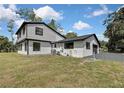 Side exterior view of the home, featuring a garage and an expansive lawn at 19003 Cedar Ln, Lutz, FL 33548