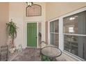 Covered front entrance features a glass top table with seating area, and green door at 1901 E Del Webb Blvd, Sun City Center, FL 33573