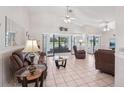 Spacious living room with tile flooring, ceiling fans, and sliding glass doors to lanai with lake views at 1901 E Del Webb Blvd, Sun City Center, FL 33573